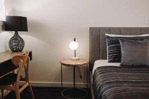 a bedroom with a bed and a table with a lamp at Port Lincoln Shark Apartment 4 in Port Lincoln +2 photos