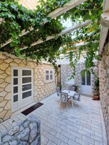 a patio with a table and chairs under a pergola at Villa Jozefina in Dubrovnik