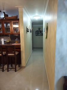 a hallway with a table and a dining room at Jardines de tu sueño. in Santiago de los Caballeros