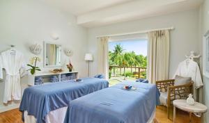 two blue beds in a room with a window at Calabash Hotel in Saint Georgeʼs +75 photos