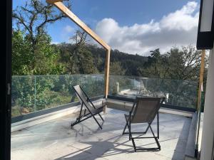 two chairs sitting on the balcony of a house at Cerrado das Fontainhas in Almargem do Bispo