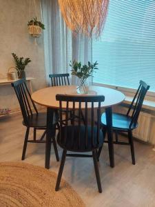 a dining room table and chairs with a vase on it at Ihastuttava kaksio Pieksämäen keskustasta in Pieksamaki