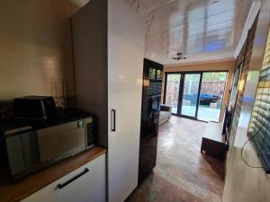 eine Küche mit einer Mikrowelle und eine Tür zum Wohnzimmer in der Unterkunft Hoogeland's Wood Cabins in Eersterivier