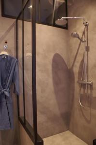 box doccia con camicia blu e accappatoio di Gîte Vassy-Etaule Spa Privatif 