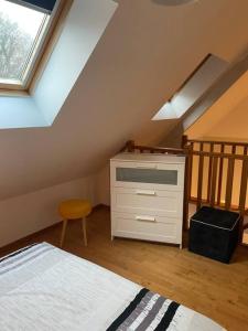 - une chambre mansardée avec un lit et une commode dans l'établissement Gite " La petite maison", à Livry