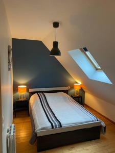 - une chambre dotée d'un lit avec deux lumières dans l'établissement Gite " La petite maison", à Livry