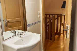 La salle de bains est pourvue d'un lavabo blanc et d'une porte. dans l'établissement Gite " La petite maison", à Livry