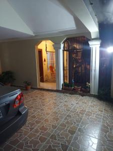 a living room with a car parked on a stone floor at Jardines de tu sueño. in Santiago de los Caballeros