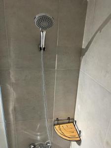 y baño con ducha con cabezal de ducha. en Departamentos del Sol para 4 personas Reciclado a Nuevo en Mendoza
