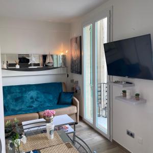 sala de estar con sofá y TV de pantalla plana en NICE City-Center 80m to the SEA / BEACH, en Niza