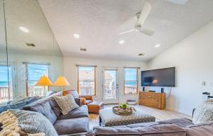 a living room with a couch and a flat screen tv at OCTIPI Your SenSEAS in Kitty Hawk