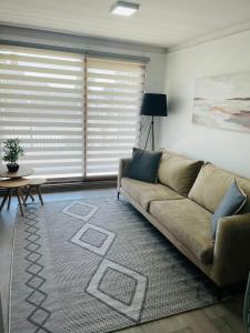 uma sala de estar com um sofá e uma mesa em Inmobiliaria Avellano em Los Ángeles