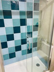 a bathroom with a shower with blue and white tiles at Inmobiliaria Avellano in Los Ángeles