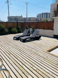 2 tumbonas en una terraza de madera con una valla en Inmobiliaria Avellano, en Los Ángeles