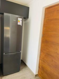 a stainless steel refrigerator next to a wooden door at Inmobiliaria Avellano in Los Ángeles