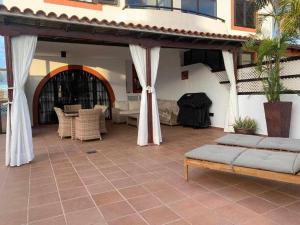 un patio de una casa con mesa y sillas en Villa Garoe, en Puerto de las Nieves