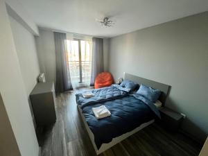 a bedroom with a bed with blue sheets and a window at Habitat 29 Apartment in Sofia