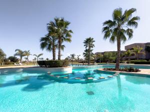 ein Pool mit Palmen im Hintergrund in der Unterkunft Les Jardins Du Paradis 3 chambres avec golf et parking gratuit in Marrakesch