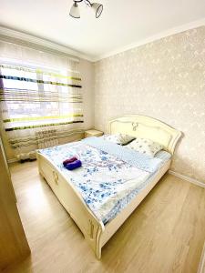 ein Schlafzimmer mit einem großen Bett in einem Zimmer in der Unterkunft Апартаменты 2 комнатная в новом ЖК in Aqtöbe