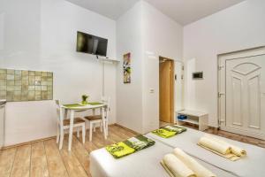 ein Wohnzimmer mit 2 Betten und einem Tisch in der Unterkunft Studio Green Oasis L&D in Pula