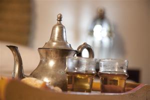 a tea kettle and two glasses on a table at Dar KamalChaoui in Bhalil