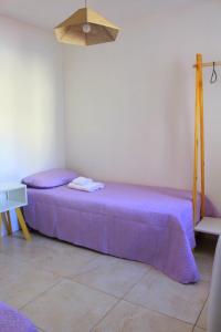 a room with two beds with purple sheets at CN departamentos in Guaymallen