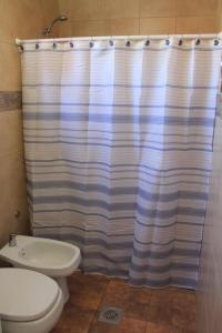 a bathroom with a toilet and a shower curtain at CN departamentos in Guaymallen