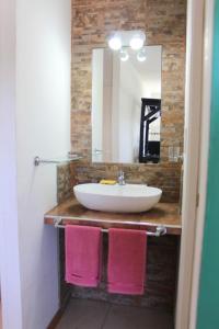 a bathroom with a sink and a mirror and pink towels at CN departamentos in Guaymallen