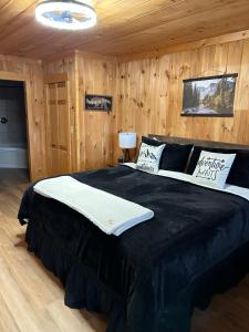 a bedroom with a large black bed with wooden walls at Classy Bear Cabin in Gatlinburg