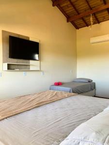 sypialnia z 2 łóżkami i telewizorem z płaskim ekranem w obiekcie Via Del Mare Flats w mieście Maraú