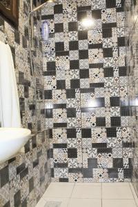 a bathroom with a black and white tiled wall at VILA VASILIJE in Novi Kneževac +40 photos