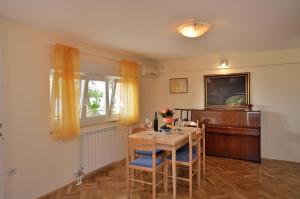 a dining room with a table and chairs and a television at Apartment Visnja in Rijeka