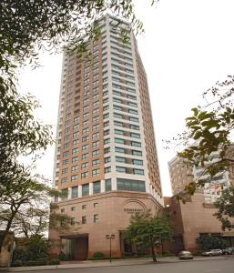a tall building with a clock on the top of it at Somerset Grand Hanoi in Hanoi