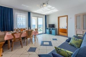 ein Wohnzimmer mit einem Tisch und einem blauen Sofa in der Unterkunft Apartments Bozana in Dramalj