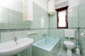 a white bathroom with a sink and a toilet at Apartment Ivanka in Banjol