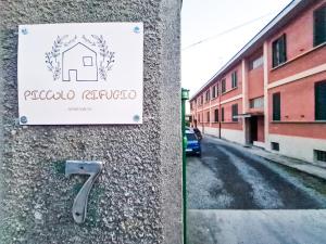 ein Schild an der Seite eines Gebäudes neben einer Straße in der Unterkunft Piccolo Rifugio in Sandigliano