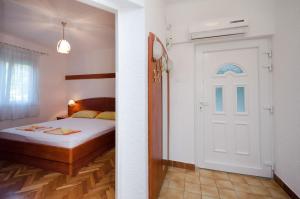 a bedroom with a bed and a white door at Apartments Zorka in Kampor
