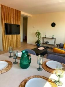 una mesa con un jarrón verde encima en SUITE PLAYA GIJON CENTRO, apartamento nuevo, 5 huéspedes VUT-3622-AS en Gijón