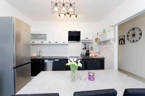 a kitchen with a table with a vase of flowers on it at Apartment Marica Sanja in Palit