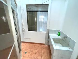 La salle de bains blanche est pourvue d'une fenêtre et d'un lavabo. dans l'établissement Departamento completo a minutos de playas, à Barranca
