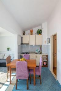 Il comprend une cuisine et une salle à manger avec une table et des chaises en bois. dans l'établissement Apartments Tolj, à Igrane