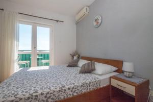 a bedroom with a bed with a clock on the wall at Apartments Tolj in Igrane