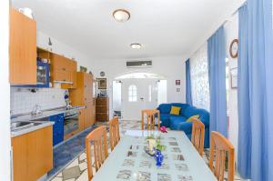 a kitchen and living room with a table and a blue couch at House Mladen in Grohote