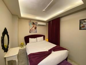 a bedroom with a bed and a desk and a mirror at ŞİRİNYER APART OTEL in İzmir