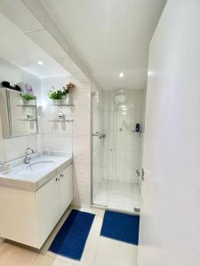 baño blanco con ducha y lavamanos en Beach Apartment, Rua Navegantes - Boa Viagem, en Recife