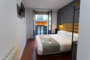 a bedroom with a bed and a brick wall at Casual Mardones in Bilbao