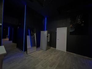 um quarto escuro com luzes azuis e um frigorífico em Rio Hostel em Madrid