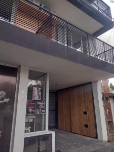 Casa con puerta de madera y balcón en Serranos Apart en Tandil