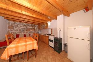una cucina con tavolo e frigorifero bianco di House Paklenica stone beauty a Starigrad-Paklenica (Ortopula)
