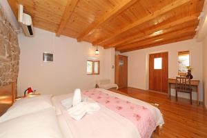 una camera da letto con un grande letto bianco e soffitti in legno di House Paklenica stone beauty a Starigrad-Paklenica (Ortopula)